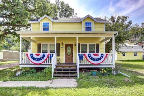 a yellow house with red white and blue flags on it at Grandma Goodnight's just 3 Miles from Mt-Rushmore in Keystone