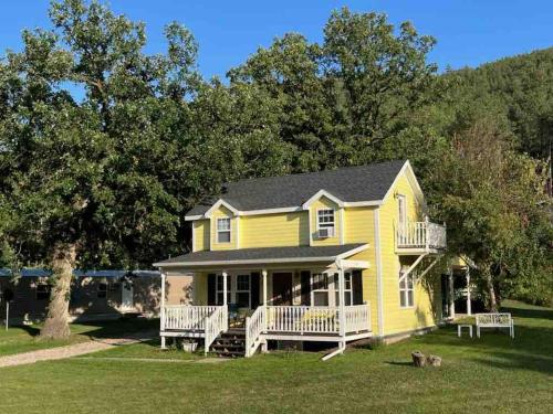 a yellow house with two benches in front of it at Grandma Goodnight's just 3 Miles from Mt-Rushmore in Keystone