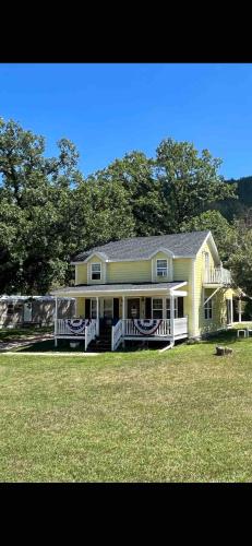 a large yellow house with a large front porch at Grandma Goodnight's just 3 Miles from Mt-Rushmore in Keystone