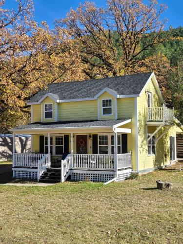a yellow house with a white porch and a yard at Grandma Goodnight's just 3 Miles from Mt-Rushmore in Keystone