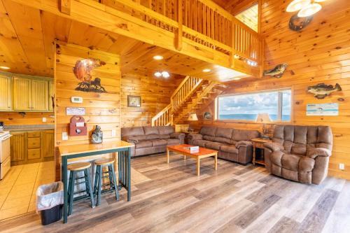 a living room with couches and a table in a cabin at Fish Tales Cabin with a private hot tub in Bryant