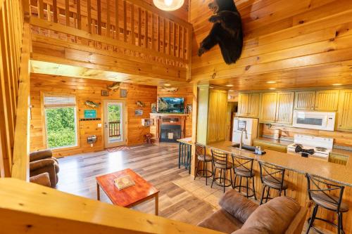 a large living room with a kitchen and a bar at Fish Tales Cabin with a private hot tub in Bryant