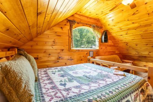 a bedroom with a bed in a wooden cabin at Fish Tales Cabin with a private hot tub in Bryant
