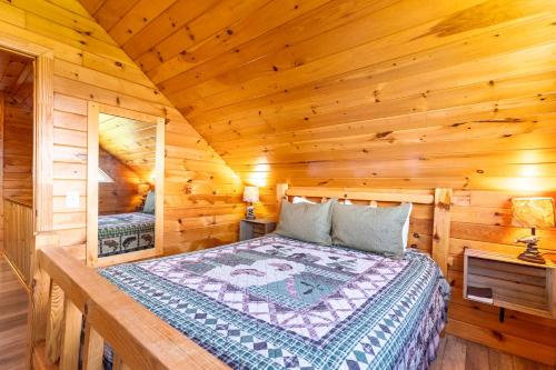 a bedroom with a bed in a log cabin at Fish Tales Cabin with a private hot tub in Bryant