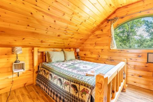 a bedroom of a log cabin with a bed in it at Fish Tales Cabin with a private hot tub in Bryant