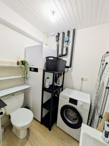 a bathroom with a washing machine and a washer at La Maison d'Emile in Sévérac d' Aveyron