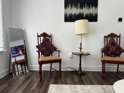 a living room with two chairs and a lamp at Three Bedroom Spacious Bangalow with Free Parking, closer to commercial area and highways in Mississauga