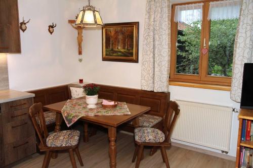 a dining room with a table and chairs and a window at Bocksleitnerhof in Wackersberg