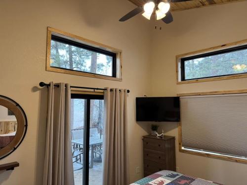 a bedroom with a bed and a tv and windows at The Bonnie View in Keystone