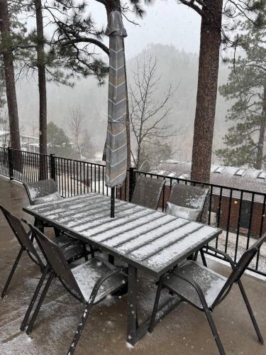a picnic table in the snow with a umbrella at The Bonnie View in Keystone
