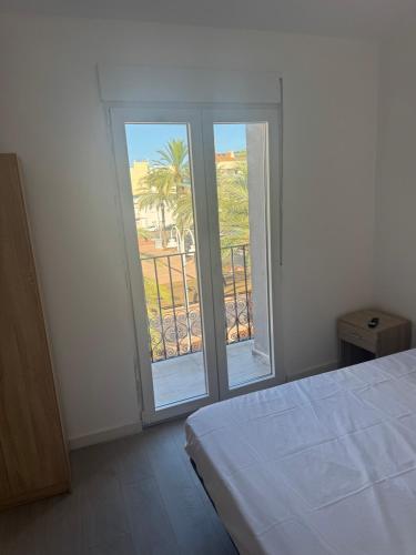 a bedroom with a bed and sliding glass doors at Nbm in Puerto de Gandía