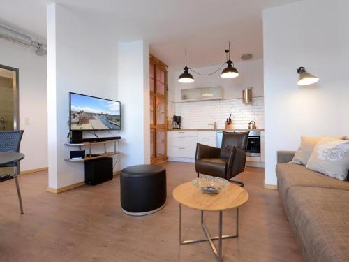 a living room with a couch and a table and a kitchen at Ohlerich Speicher App_ 07 in Wismar