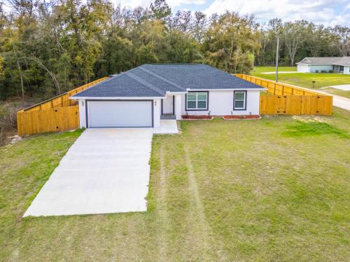 a house with a large yard with a fence at Rainbow Springs Paradise in Dunnellon