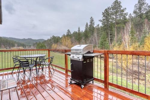 a grill on a deck with a table and chairs at Cozy Creekside Retreat in Keystone