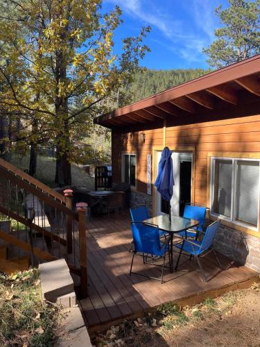 a wooden deck with a table and chairs on it at Bullion Street Hideaway in Keystone