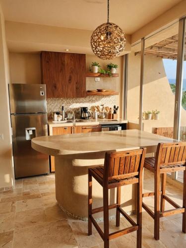 a kitchen with a large island in the middle at Punta Majahua by PRC Hospitality in La Majahua