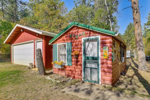 a small red house with a garage in a yard at Grizzly Gulch Cabin Historic in Keystone