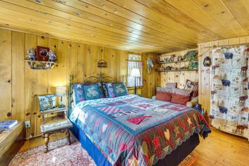 a bedroom with a bed in a room with wooden walls at Grizzly Gulch Cabin Historic in Keystone