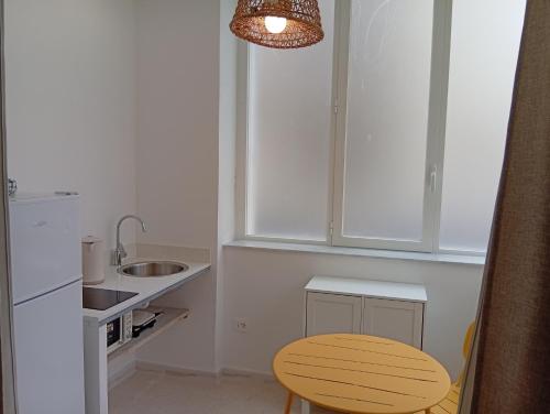 a kitchen with a wooden stool and a sink at Giosuero Beach in Alghero