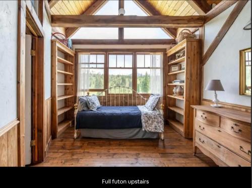 a bedroom with a bed in a room with wooden floors at Breathtaking Cabin Away From Reality in Clark