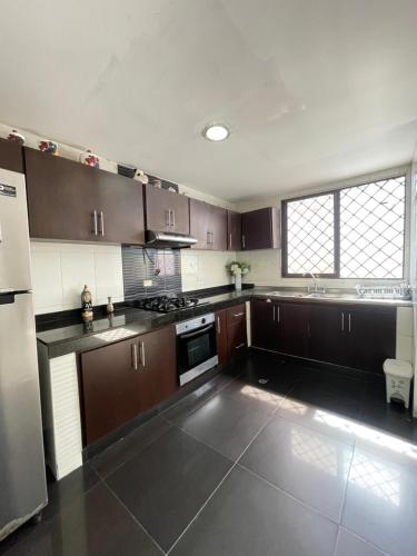 a kitchen with brown cabinets and a stove top oven at Baranoa House in Barranquilla
