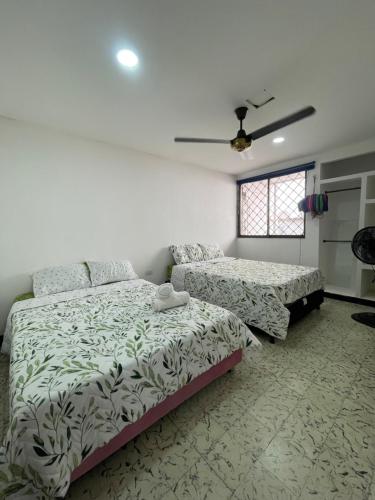 a bedroom with two beds and a window at Baranoa House in Barranquilla
