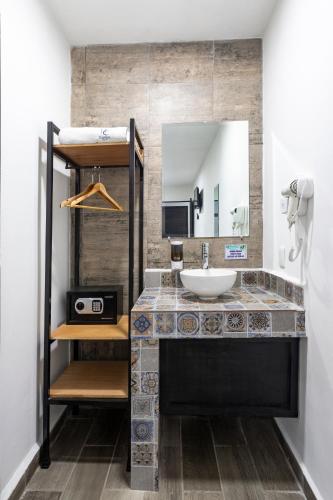 a bathroom with a sink and a mirror at Capital Hotel Saltillo in Saltillo