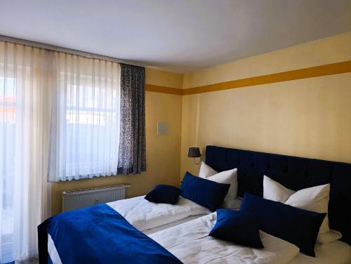 a bedroom with two beds with blue pillows at Doppelzimmer TE01 in Kühlungsborn