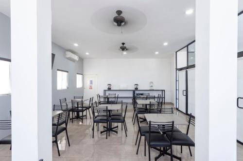 a dining room with tables and black chairs at Capital Hotel Saltillo in Saltillo