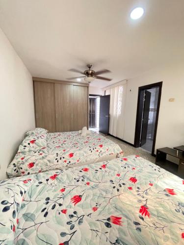 a bedroom with a bed with red flowers on it at Baranoa House in Barranquilla