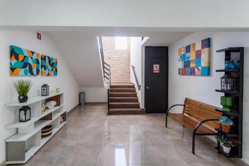 a hallway with a bench and stairs in a house at Capital Hotel Saltillo in Saltillo