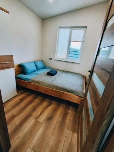 a small bedroom with a bed and a window at Sodyba Miško pakrašty in Gailiūnai