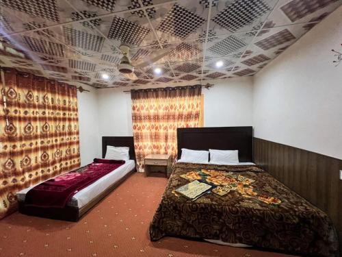 ein Schlafzimmer mit zwei Betten und einer Decke in der Unterkunft Orophile Nest And Resturent in Skardu