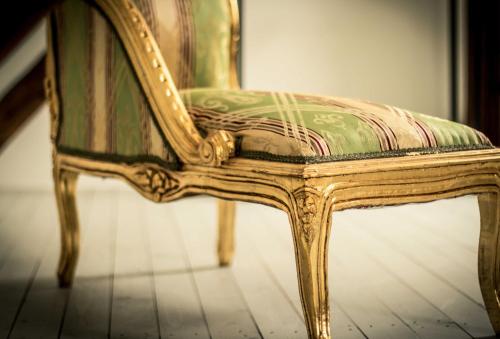 a green and gold chair sitting on a floor at Chalet Sch l afbock in Priesteblich