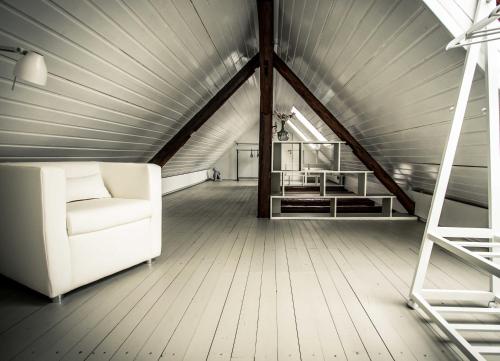 a living room with a white couch and a ladder at Chalet Sch l afbock in Priesteblich