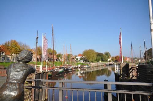 a statue of a woman looking over a canal with boats at Nr 46 - Ferienhaus Mühlenblick Nähe Museumshafen in Carolinensiel