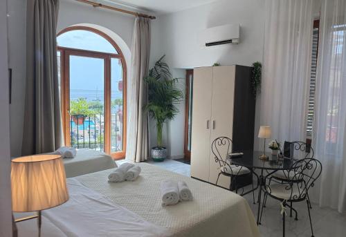 a hotel room with two beds and a large window at La Maison Rose in Maiori