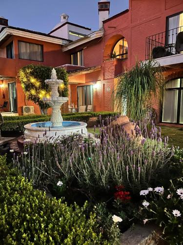a fountain in a garden in front of a building at Hotel Villas Ajijic, Ajijic Chapala Jalisco in Ajijic
