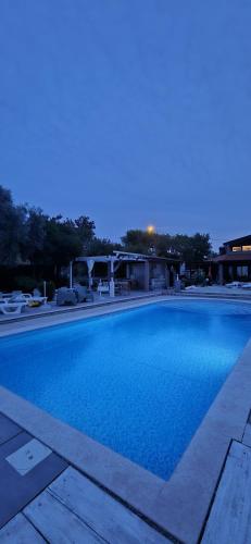 a large blue swimming pool at night at Casa Perla Holidays in Juraši