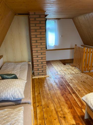 an attic room with two beds and a window at Rekreační chata in Hodonín