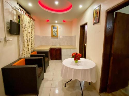 a kitchen with a table with a vase of flowers on it at Gorilla African Guest House in Entebbe