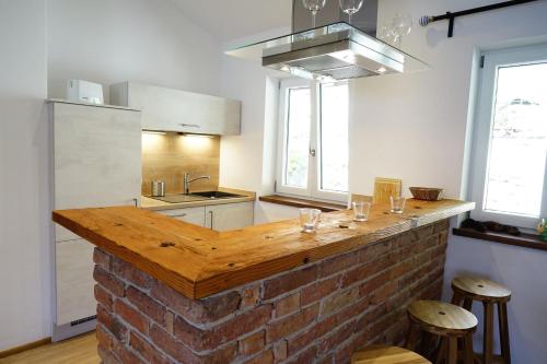 a kitchen with a brick counter with stools at Ferienwohnungen Rosenhof in Tegernsee