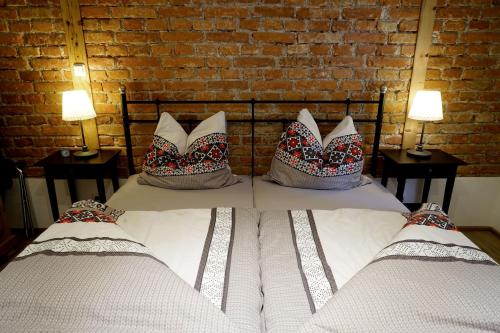 two beds with pillows sitting next to a brick wall at Ferienwohnungen Rosenhof in Tegernsee