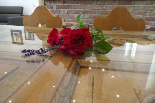 a bouquet of red roses sitting on a table at Ferienwohnungen Rosenhof in Tegernsee