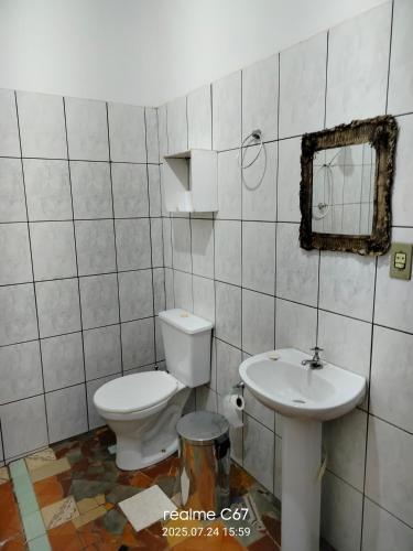 a bathroom with a toilet and a sink at Paraíso dás águas in Botelhos