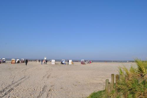 a group of people walking on the beach at Nr 23 - Ferienhaus Mittelweg in Carolinensiel