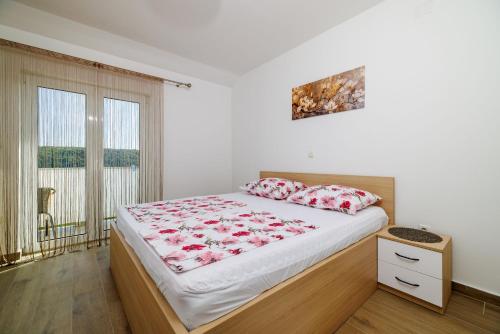 1 dormitorio con 1 cama grande con sábanas rojas y blancas en Apartment Ren, en Kampor