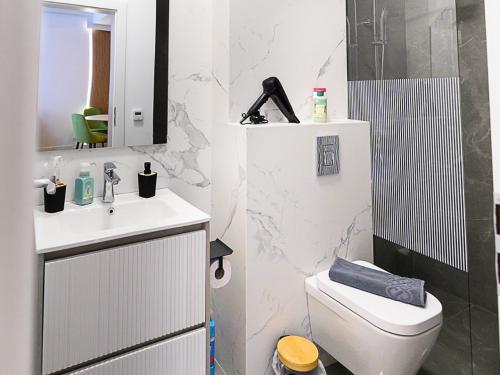 a bathroom with a toilet and a sink and a mirror at Aparthotel Madonna Residence Petunilor in Craiova