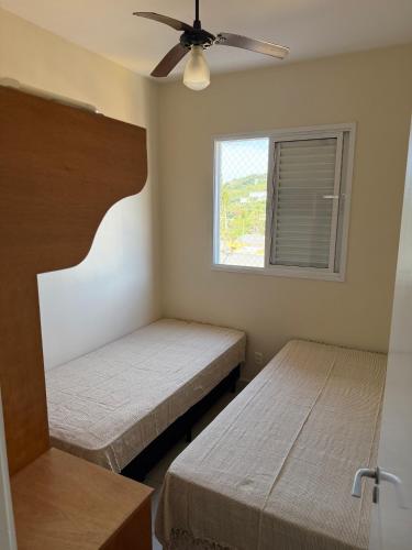 a bedroom with two beds and a ceiling fan at Apartamento em Ubatuba! A 100m da praia das Toninhas! in Ubatuba