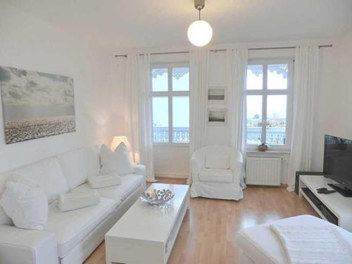 a living room with a white couch and a tv at Villa Melanie in Sassnitz